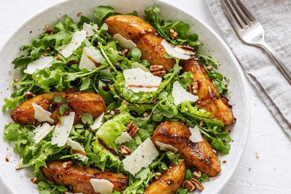 Healthy grilled chicken salad with mixed greens, pecans, and Parmesan cheese.