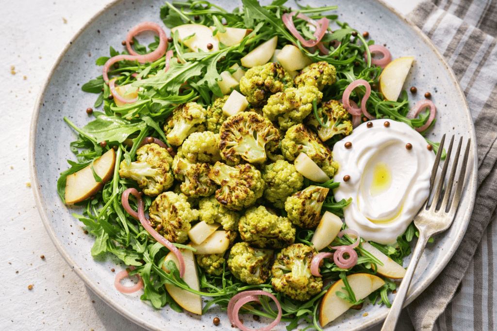 Healthy roasted cauliflower salad with fresh greens and creamy yogurt dressing.