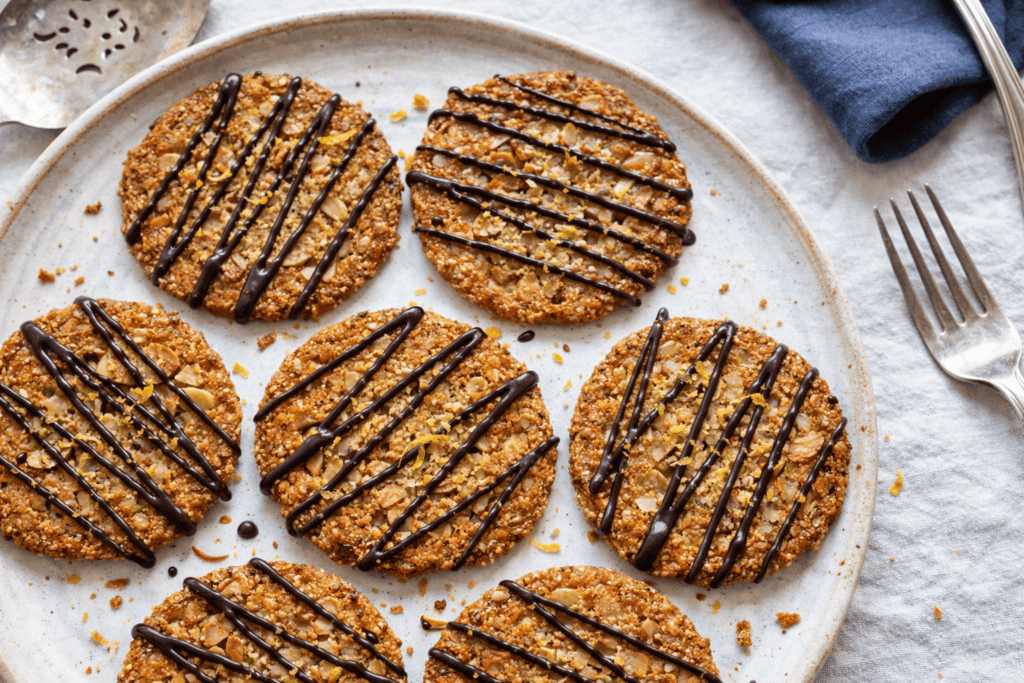 Delicious cookie bites drizzled with chocolate on a white plate. Perfect for snacking or dessert.
