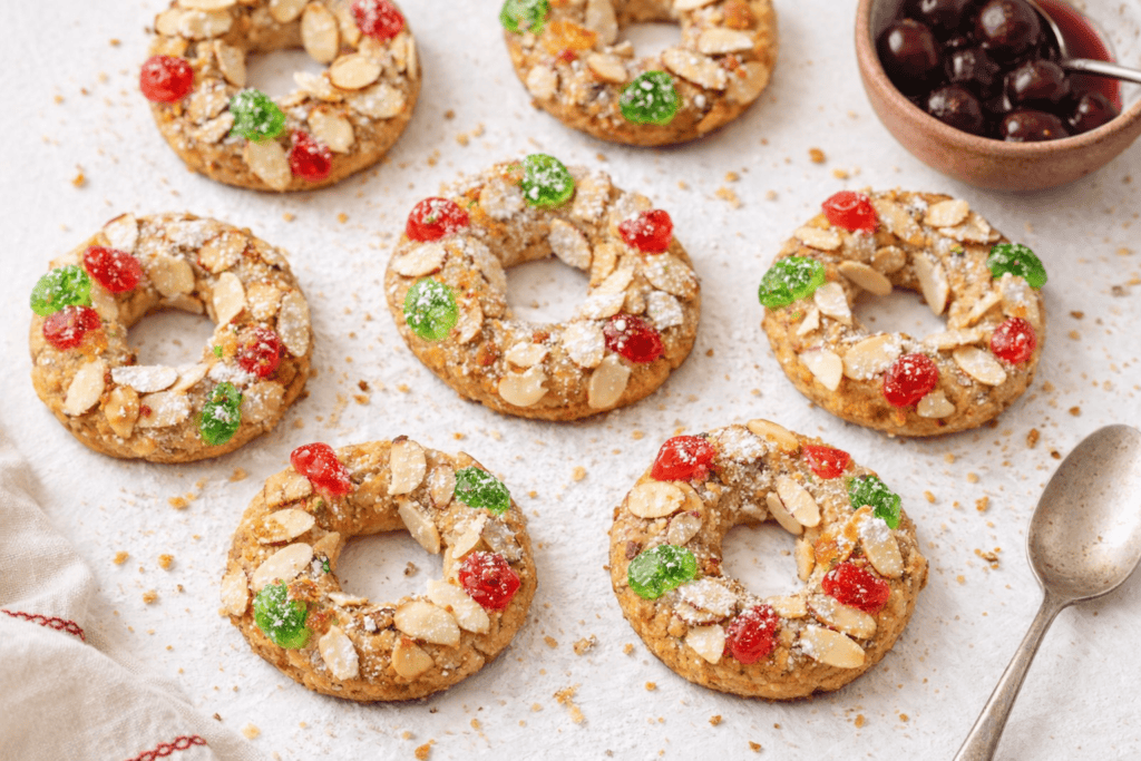 Almond cookies decorated with colorful red and green candies, perfect for holiday treats.